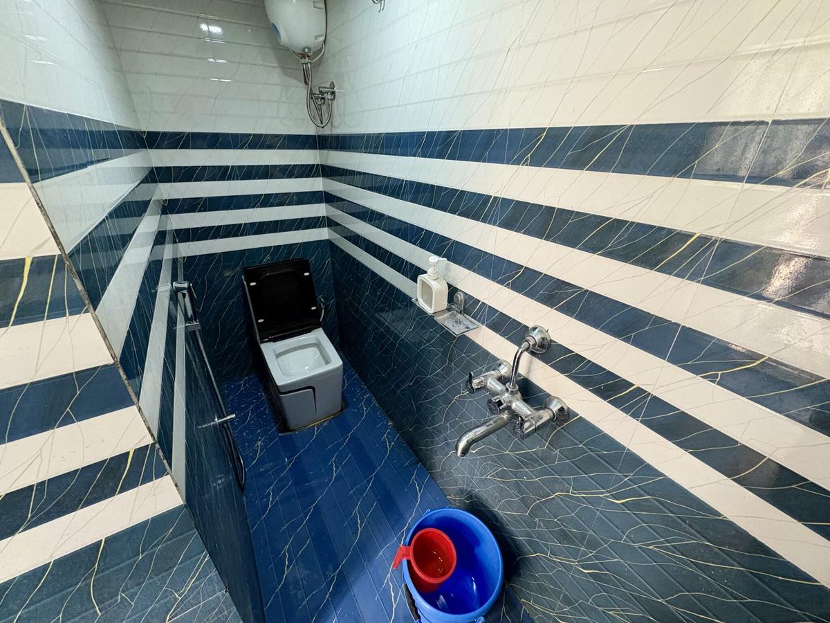 Bathroom with blue tiles at New Metro Guest House Kolkata